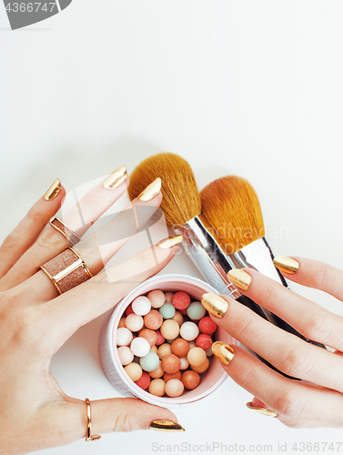 Image of woman hands with golden manicure  many rings holding brushes, make up artist stuff stylish and pure