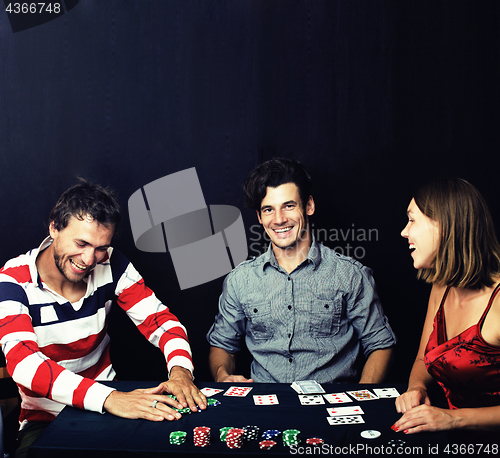 Image of young people playing poker on black background