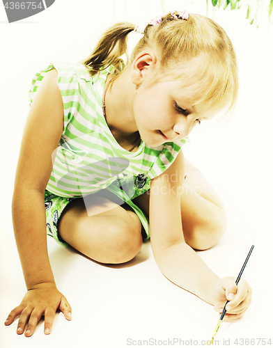 Image of little cute blond girl painting isolated on white background