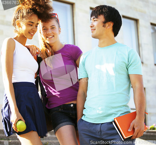 Image of cute group of teenages at the building of university with books huggings, back to school