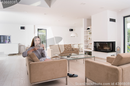 Image of young woman in a bathrobe enjoying morning coffee