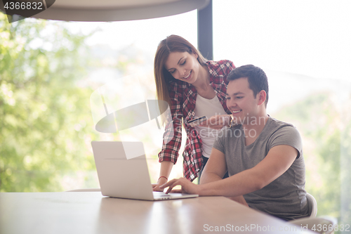 Image of happy young couple buying online