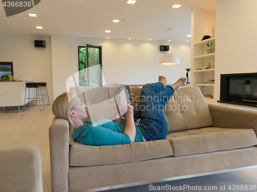 Image of woman on sofa using tablet computer