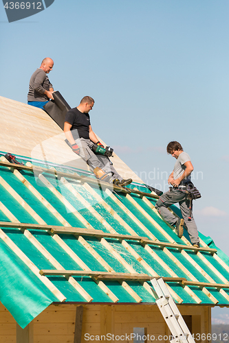 Image of Builders at work with wooden roof construction.