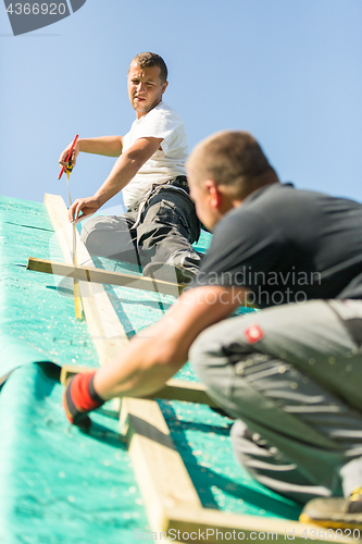 Image of Builders at work with wooden roof construction.