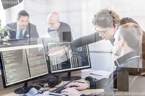 Image of Startup business problem solving. Software developers working on desktop computer.