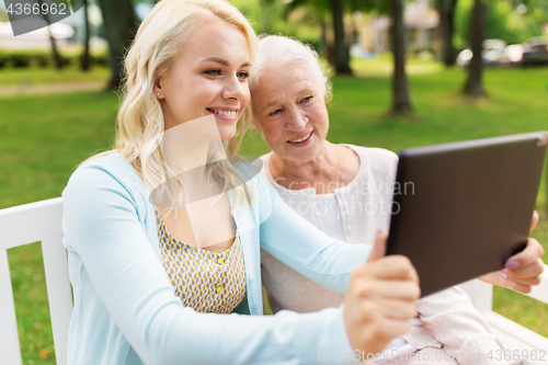 Image of daughter with tablet pc and senior mother at park