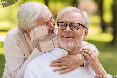 Image of happy senior couple sitting on bench at park