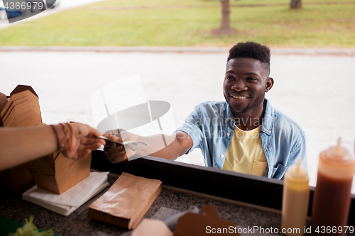 Image of african american man buying wok at food truck