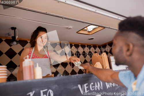 Image of african american man buying wok at food truck