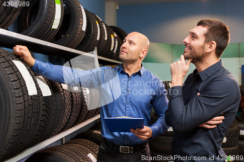 Image of customer and salesman at car service or auto store