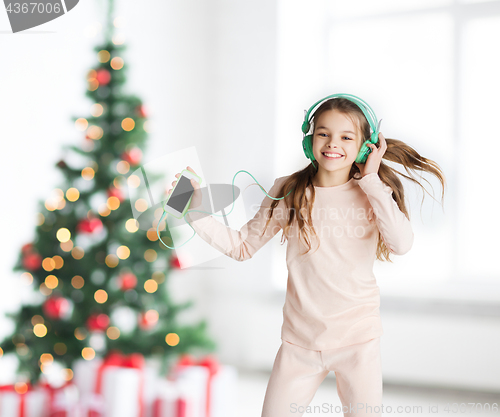 Image of girl with smartphone and headphones at christmas