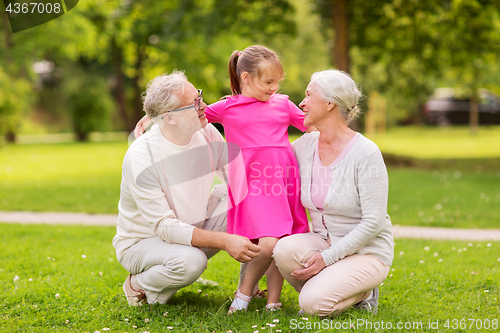 Image of senior grandparents and granddaughter at park