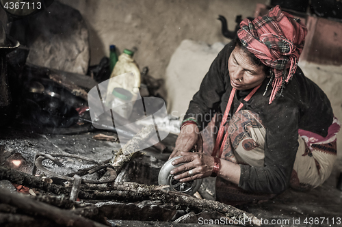 Image of Kneeling woman in kitchen in Nepal