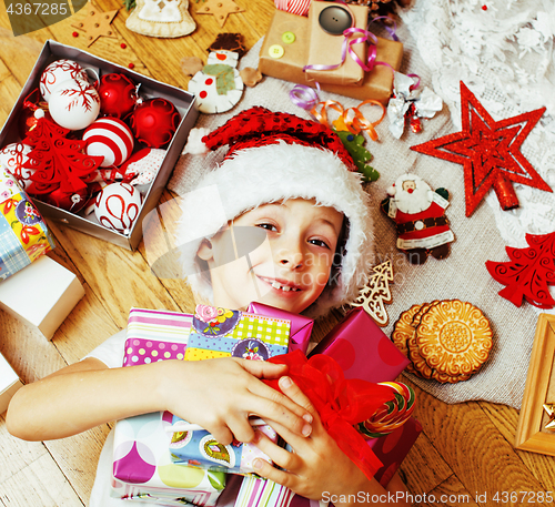 Image of little cute boy with Christmas gifts at home. close up emotional