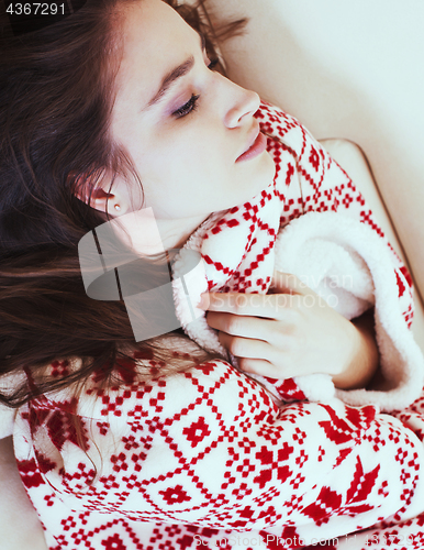 Image of young pretty brunette girl in Christmas ornament blanket getting