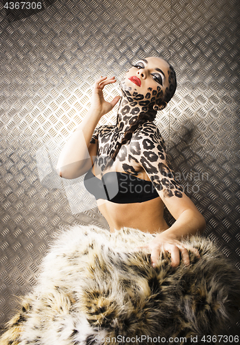 Image of young sexy woman with leopard make up all over body, cat bodyart