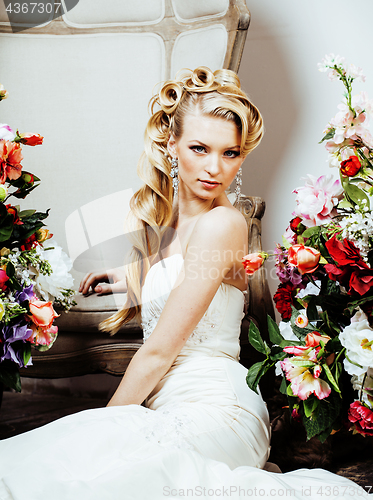 Image of beauty young blond woman bride alone in luxury vintage interior with a lot of flowers 