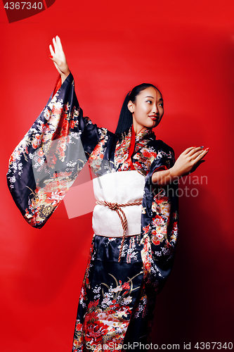 Image of young pretty geisha on red background posing in kimono, oriental people concept close up