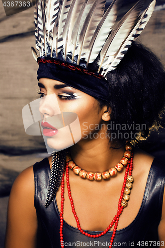 Image of young pretty woman with make up like red indian, futher in hair,