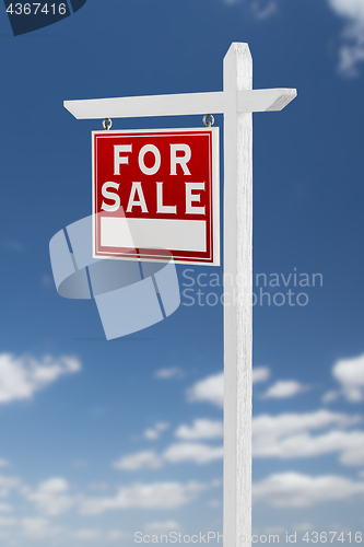 Image of Left Facing For Sale Real Estate Sign on a Blue Sky with Clouds.