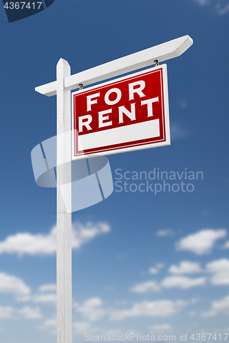 Image of Right Facing For Rent Real Estate Sign on a Blue Sky with Clouds