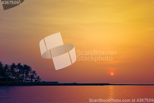 Image of Beautiful colorful sunrise over sea and boulders seen under the 