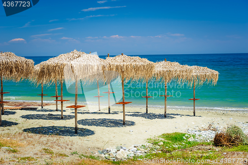 Image of reed umbrellas at empty beach