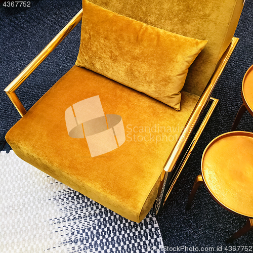 Image of Retro style dark yellow velvet armchair and golden side table