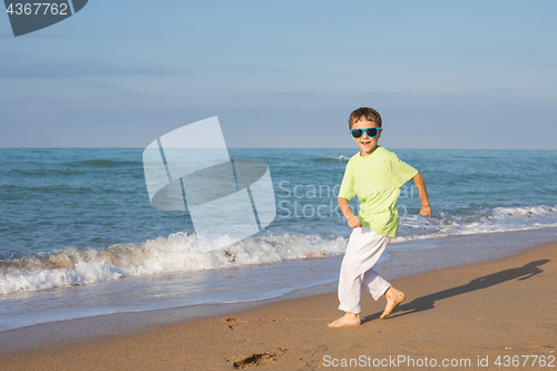 Image of  happy little boy running on the beach at the day time. 