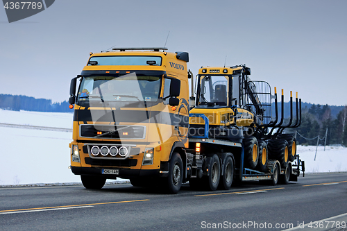 Image of Yellow Volvo FH Truck Hauls Ponsse Forest Machinery