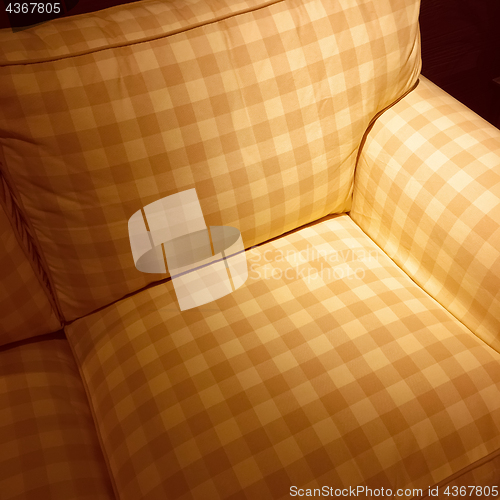 Image of Checked armchair in spotlight