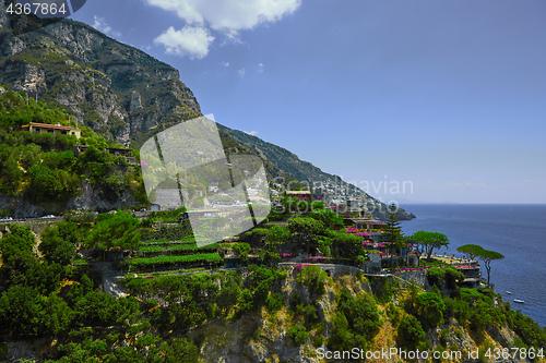 Image of One of the best resorts of Italy with old colorful villas on the steep slope, nice beach, numerous yachts and boats in harbor and medieval towers along the coast, Positano.