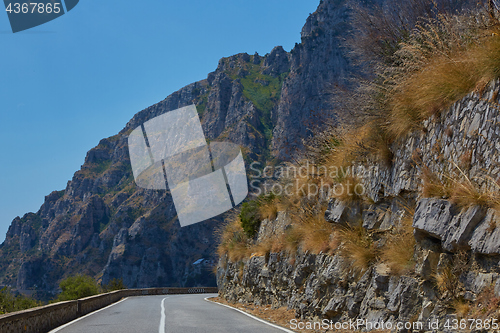 Image of Asphalt road. Colorful landscape with beautiful mountain road with a perfect asphalt. High rocks, blue sky at sunrise in summer. Vintage toning. Travel background. Highway at mountains