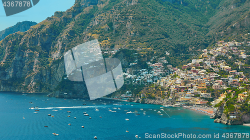 Image of One of the best resorts of Italy with old colorful villas on the steep slope, nice beach, numerous yachts and boats in harbor and medieval towers along the coast, Positano.