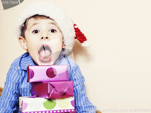 Image of little cute boy with Christmas gifts at home. close up emotional