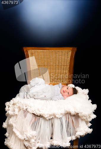 Image of Newborn baby girl with sleeping on a wooden chair