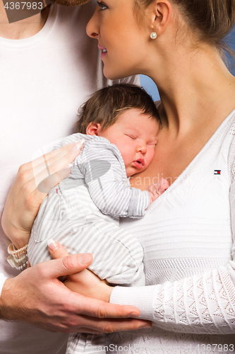 Image of Portrait of young happy couple embracing to their newborn.