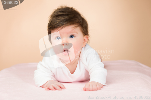 Image of Bright blue eyed 6 month old baby girl