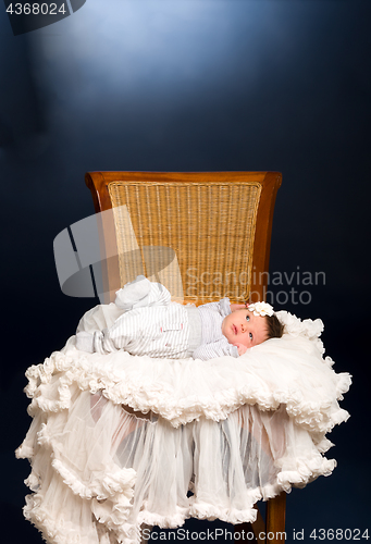 Image of Newborn baby girl with sleeping on a wooden chair