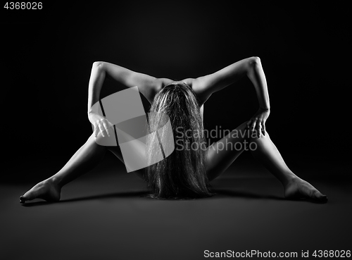 Image of Naked woman is sitting on a black background