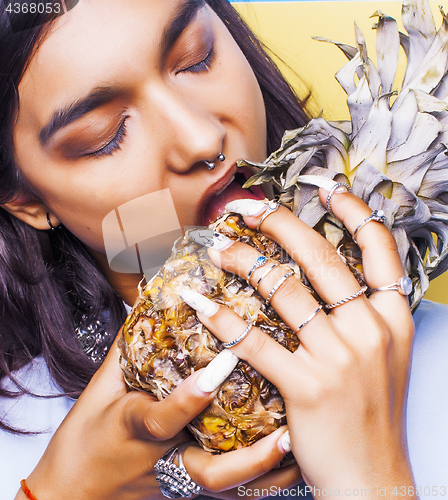 Image of lifestyle people concept. young pretty smiling indian girl with pineapple, asian summer fruits 