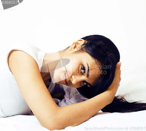 Image of young pretty tann woman in bed among white sheets having fun, tr