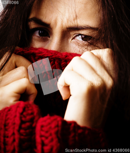 Image of young brunette gloomy woman in sweater all over her face, messed hair