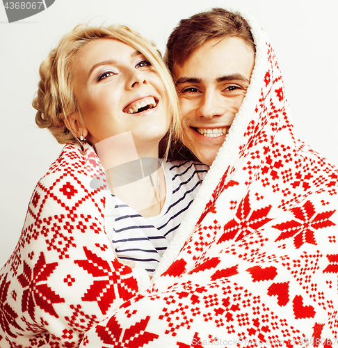 Image of young pretty teenage couple at Christmas time warming in red decorated blanket, hipster guy with his girlfriend happy smiling and hugging isolated on white background, lifestyle people concept 