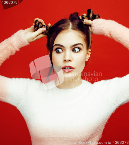 Image of young pretty emitonal posing teenage girl on bright red background, happy smiling lifestyle people concept 