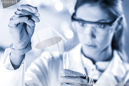 Image of Young scientist pipetting in life science laboratory.