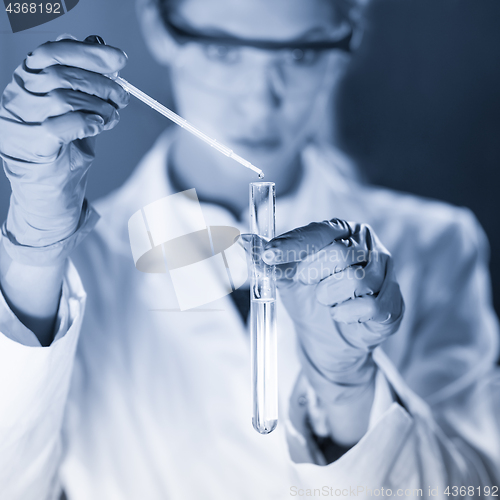 Image of Young scientist pipetting in life science laboratory.