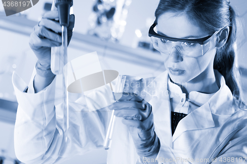 Image of Young scientist pipetting in life science laboratory.