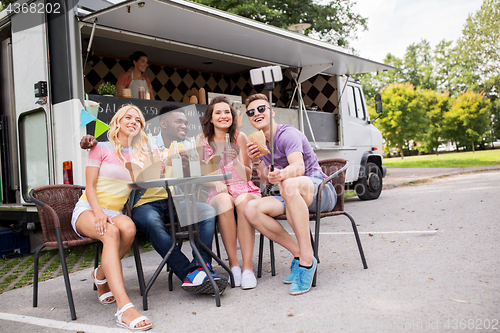 Image of happy young friends taking selfie at food truck